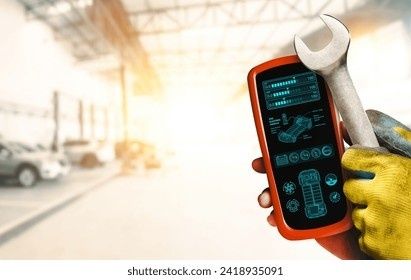 Handskbeklädd mekaniker håller en OBD2-läsare och skiftnyckel